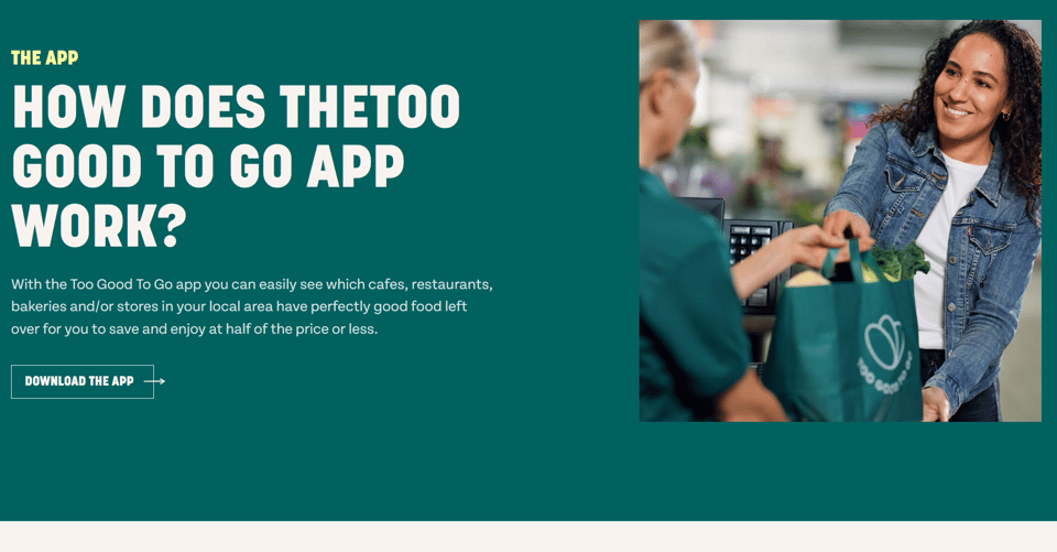 A screenshot of the Too Good to Go app website, explaining how the app works. Text on the image reads: "THE APP - HOW DOES THE TOO GOOD TO GO APP WORK? - With the Too Good To Go app you can easily see which cafes, restaurants, bakeries and/or stores in your local area have perfectly good food left over for you to save and enjoy at half of the price or less." Below this is a link to download the app.