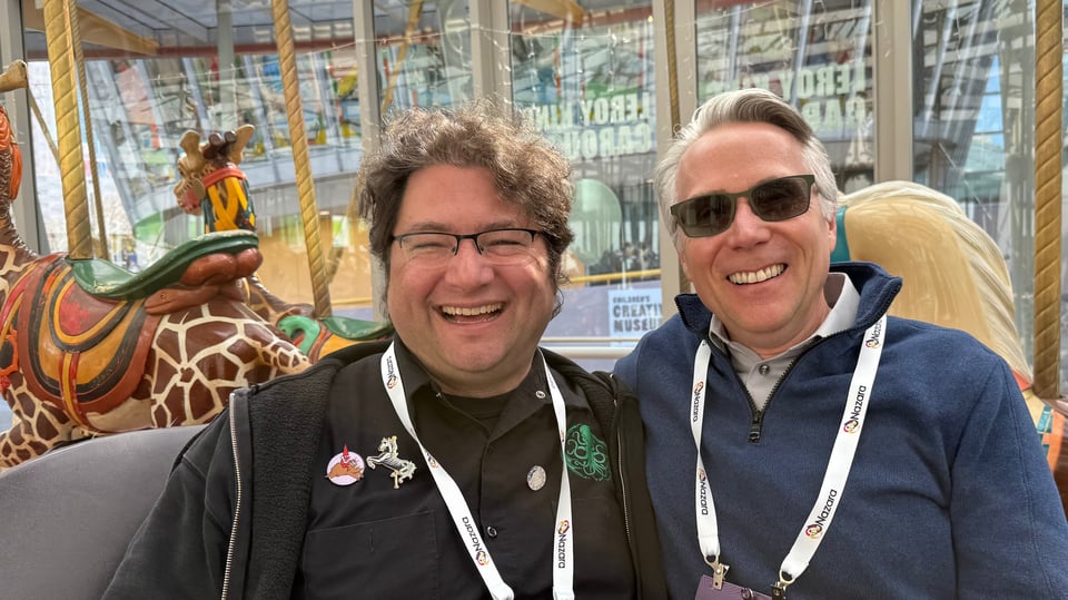 Seg and Mark riding a chariot on the carousel.