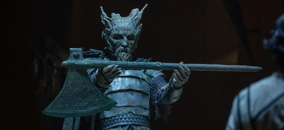 Green Knight holding out an axe