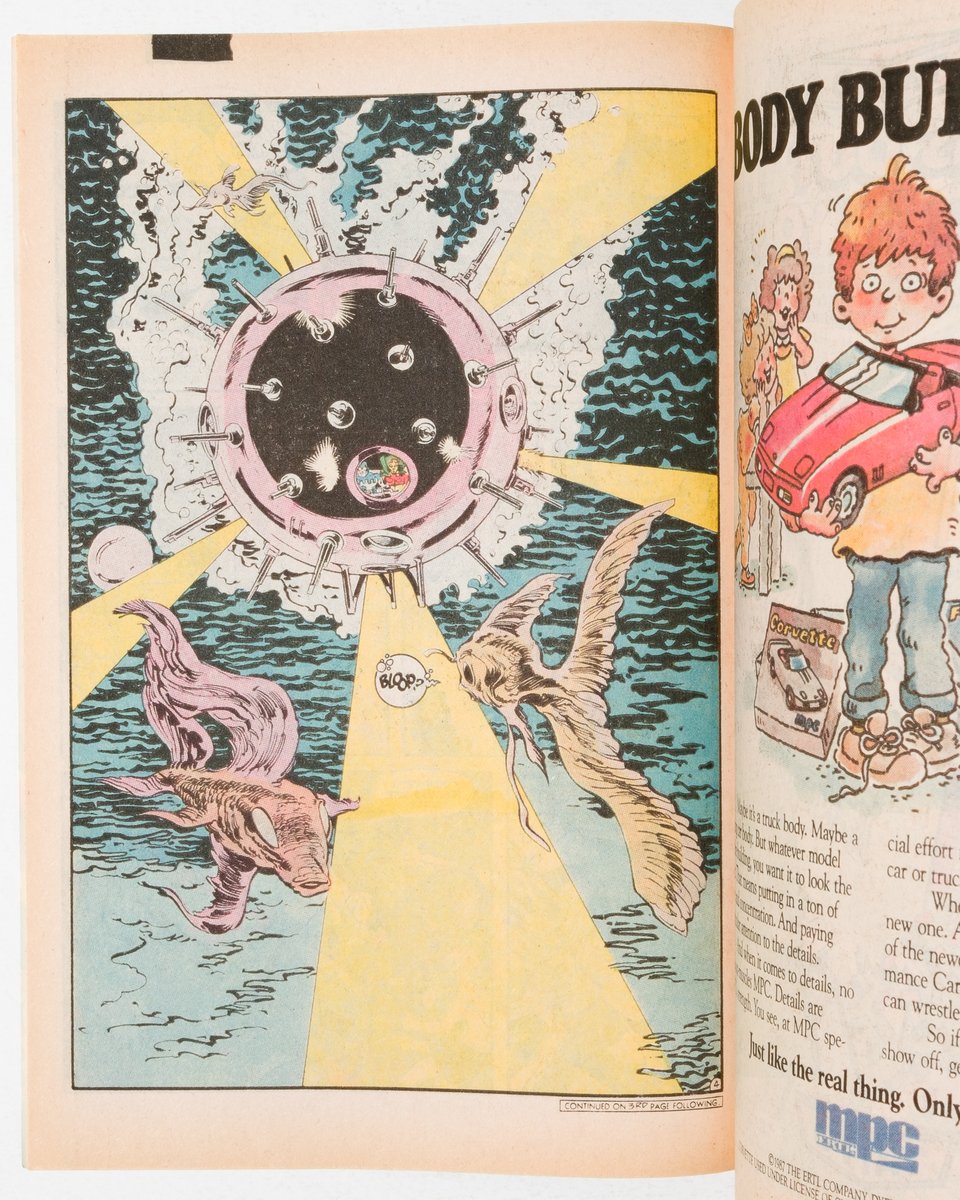 Interior page of Millennium. A spiky ball shaped submarine goes past big fish that look like guppies