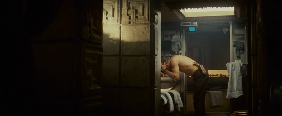 an image from Blade Runner of Harrison Ford at a sink, washing his head. he is stripped to the waist with a gun holstered to his hip.