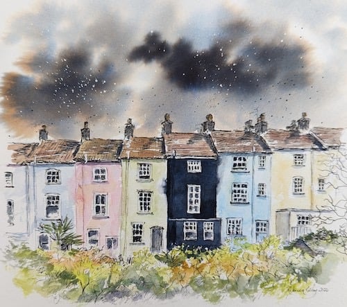 A terrace of three-story houses, painted in contrasting colours, with dark clouds.