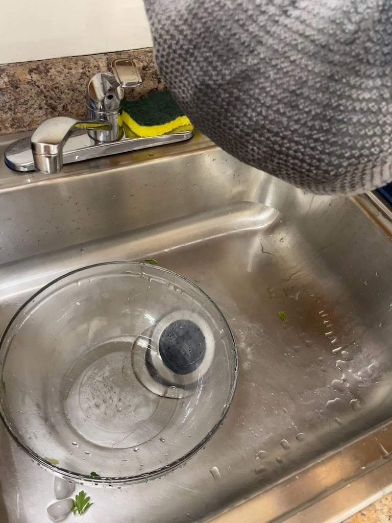 A towel bag of wet leaves over a sink