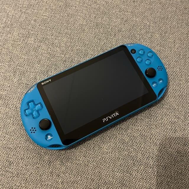 A photo of an aqua blue Playstation VITA unit.