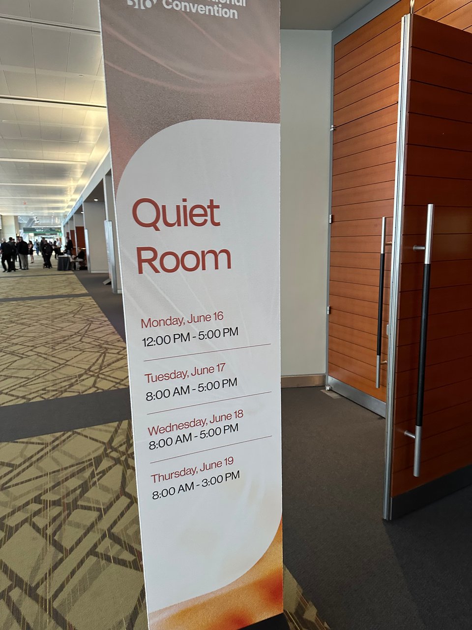 photo of a standing-banner in a convention center for a Quiet Room, with hours of operation listed