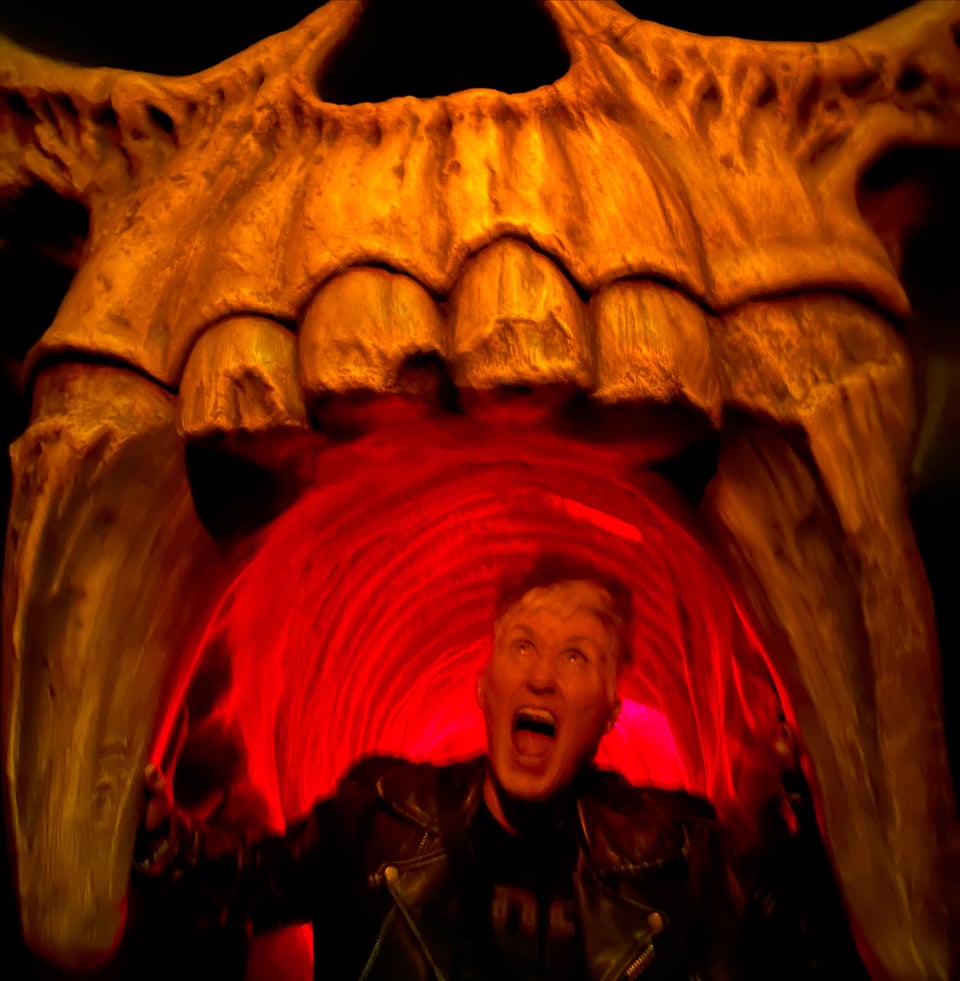 Me bathed in hellish red light, screaming inside the mouth of a giant fanged skull.