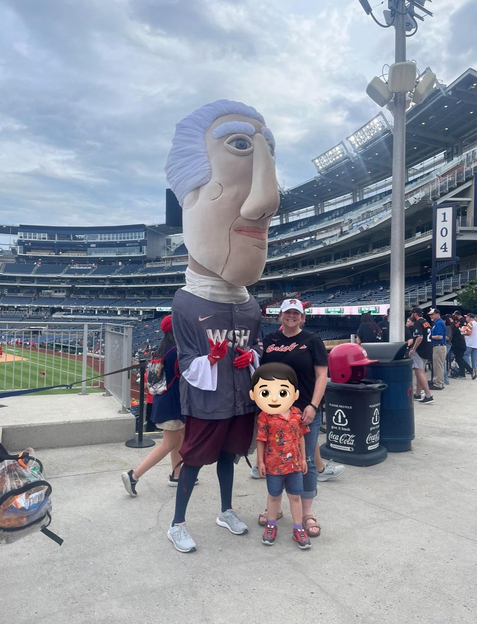 Nationals Park. A mascot in a grey jersey with an adult woman and a little boy, face obscured.