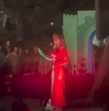 The musician Molly Lewis whistles on a performing stage.