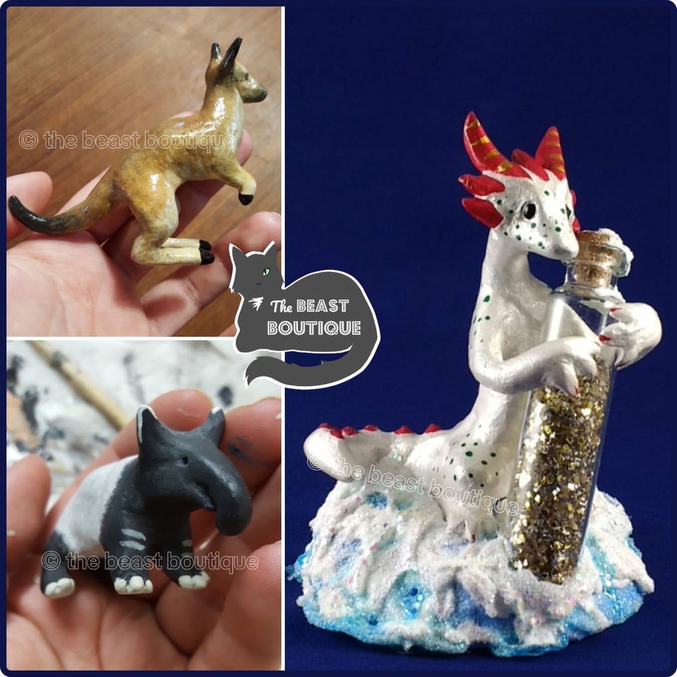 a collage showing a small kangaroo figurine in someone's hand, a tapir figurine, also being held, and a white dragon with red horns and green freckles against a blue backdrop atop a faux snow drift, holding a vial of gold glitter as large as he is.