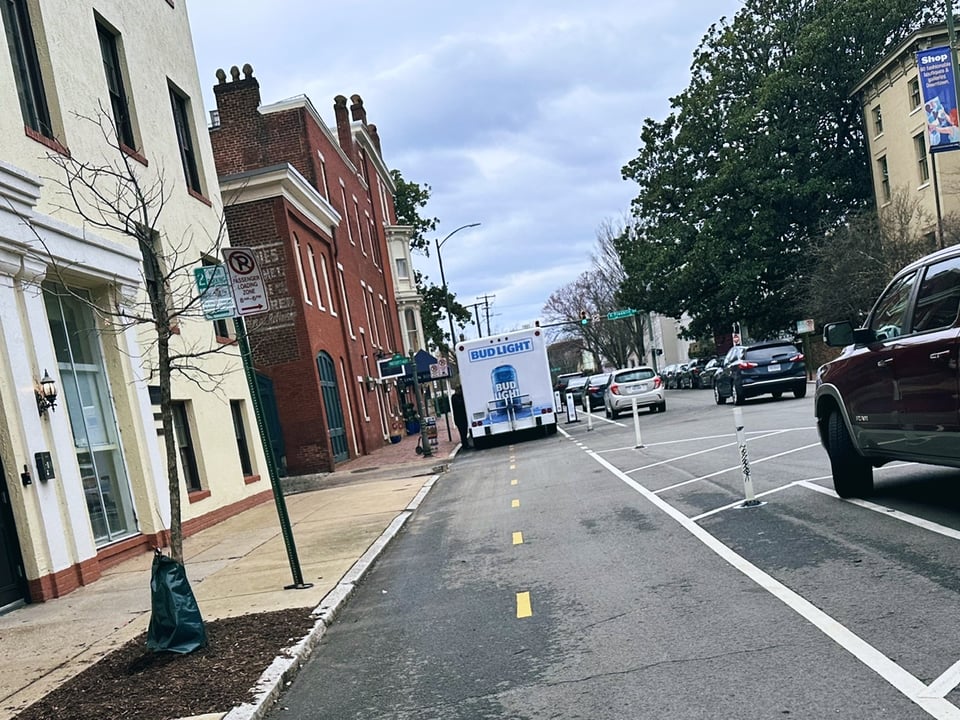 A Bud Light delivery truck parked full on in the Bike Lane next to Linden Row Inn.