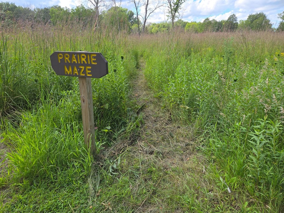 This time of year, native grasses grow so tall that every prairie trail becomes a bit of a maze. This one, designed for your little ones, is simple and easy to navigate. You’ll find this sign marking its entrance in the natural-materials playground just southwest of the mail park overlook parking lot. Check it out! / Photo by Pamela Miller