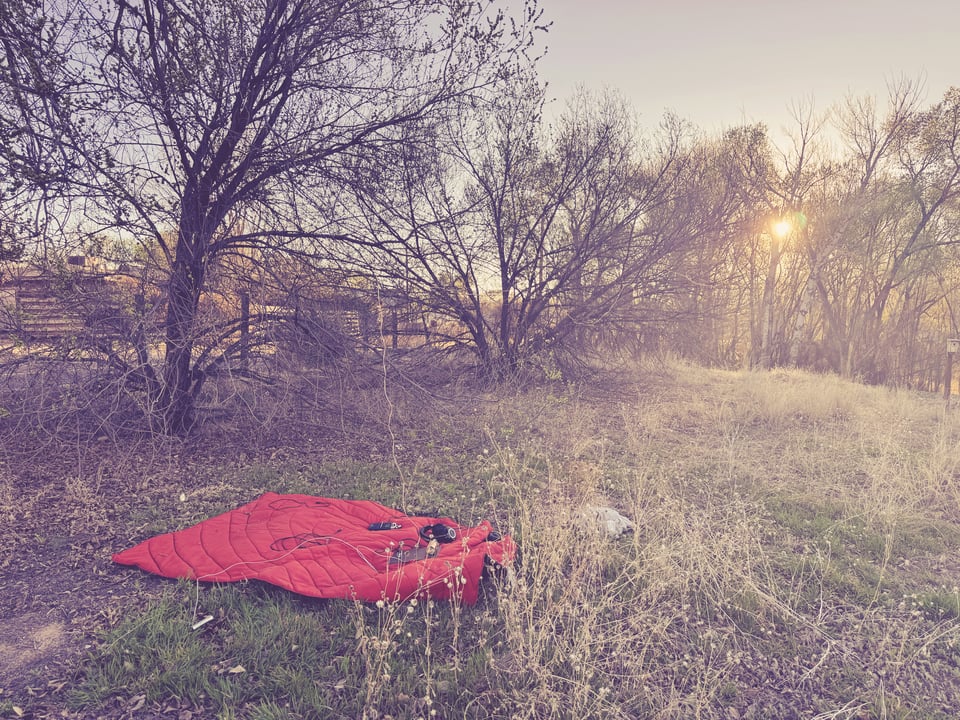 a grassy field with a orange blanket and an open wave receiver on the blanket, the sun is going down. Spring Equinox 2026, New Mexico