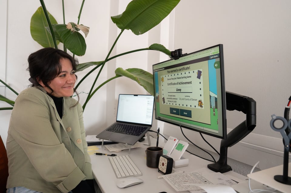 Livvy looking smilingly at a computer.