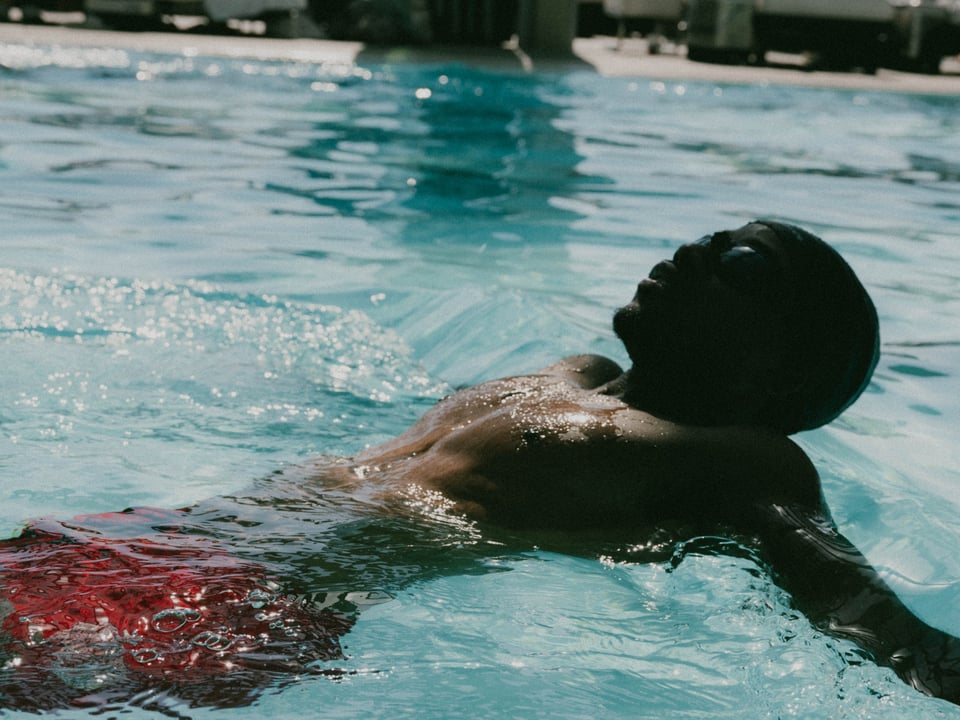 Peter floating on his back in a swimming pool.