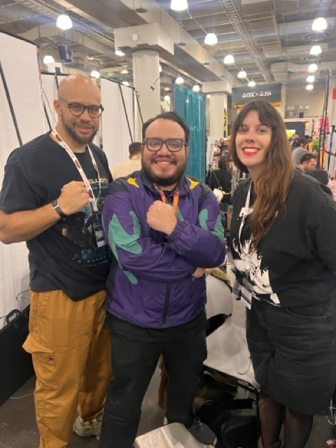 three people posing for a photo at a convention