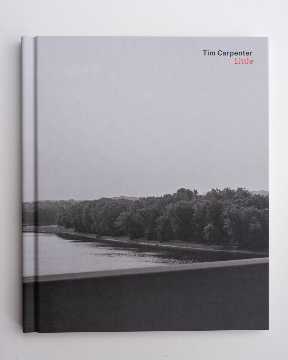 Cover of Tim Carpenter's Photo Book "Little." Image on the cover is of a landscape with sky, a line of trees, body of water and concrete railing of a bridge.