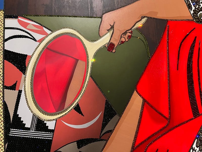 A close up of a painting shows a woman's hand holding a mirror that is pointed at her bright red skirt