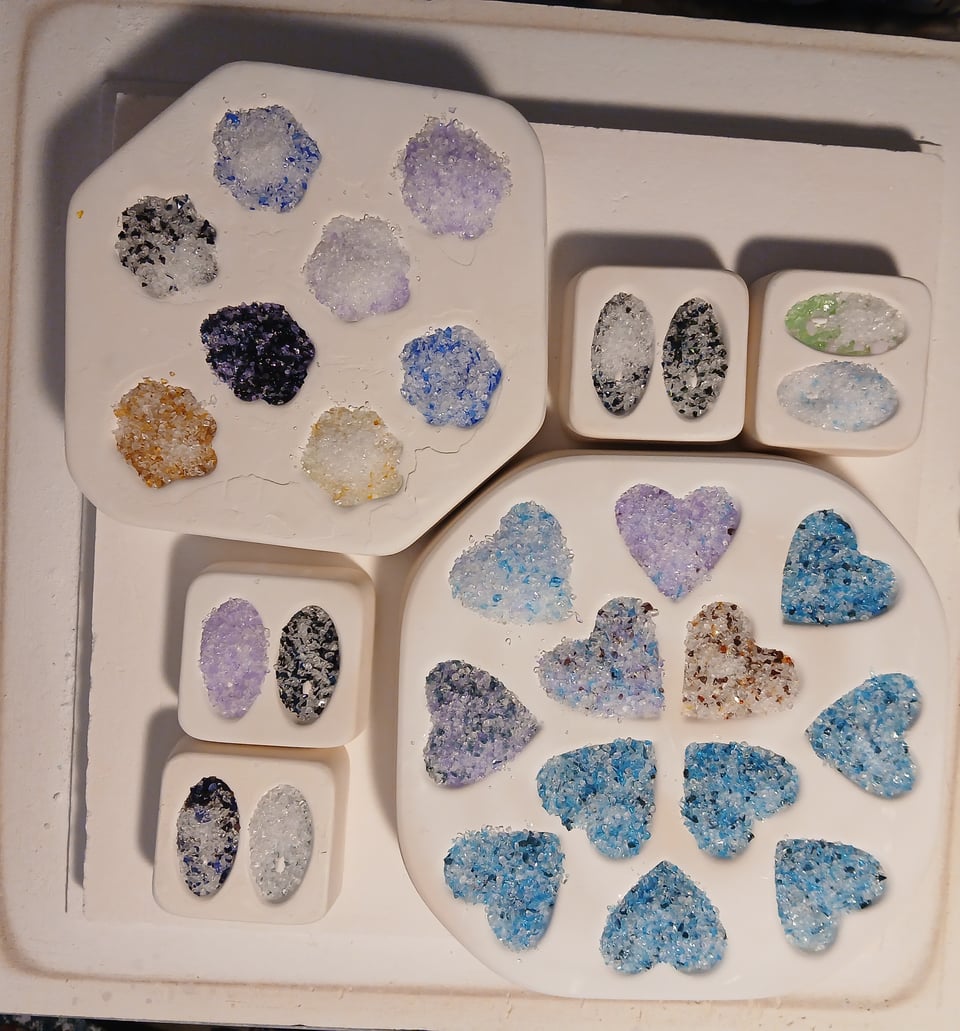 kiln shelf with various molds filled with frit