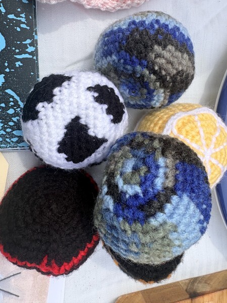 A group of hand-crocheted hacky sacks in multiple colors.