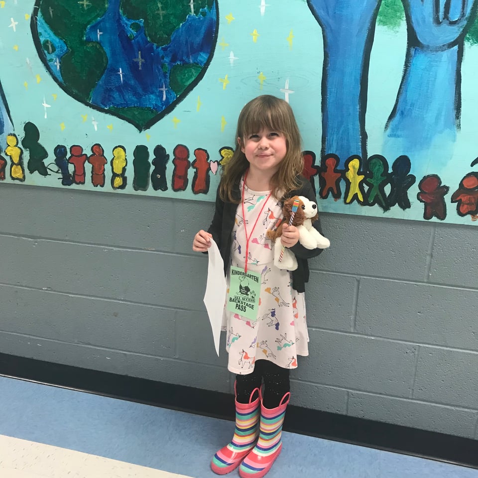 a child stands before a wall mural