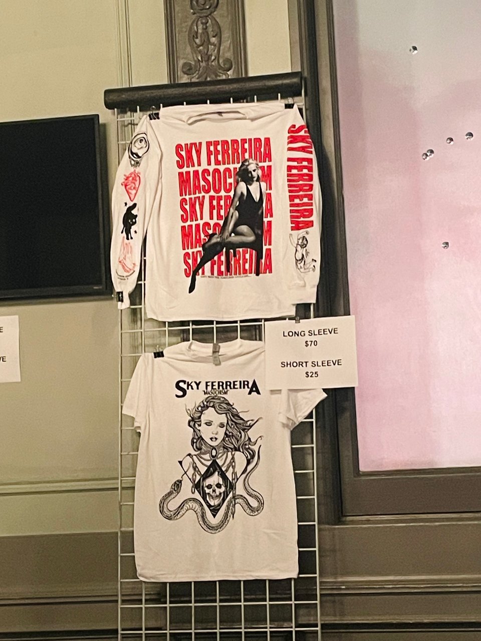 Two white shirts, one long-sleeved and one short-sleeved, merchandise for the musical artist Sky Ferreira.