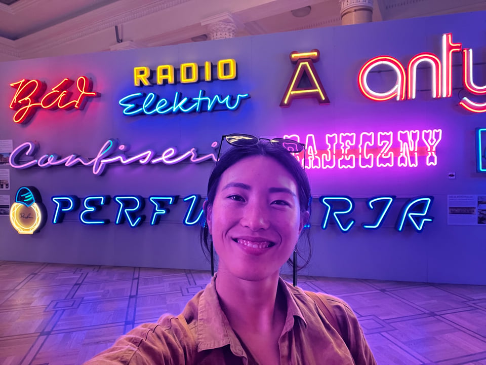 Selfie of Jenny in front of a wall of neon lights