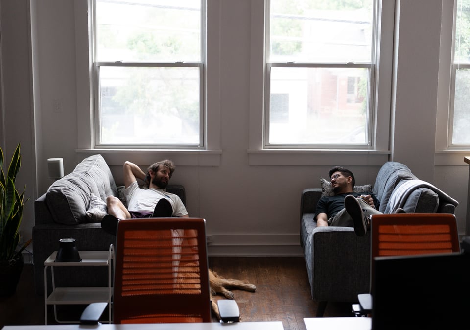 Justin and Drew lying on couches talking.