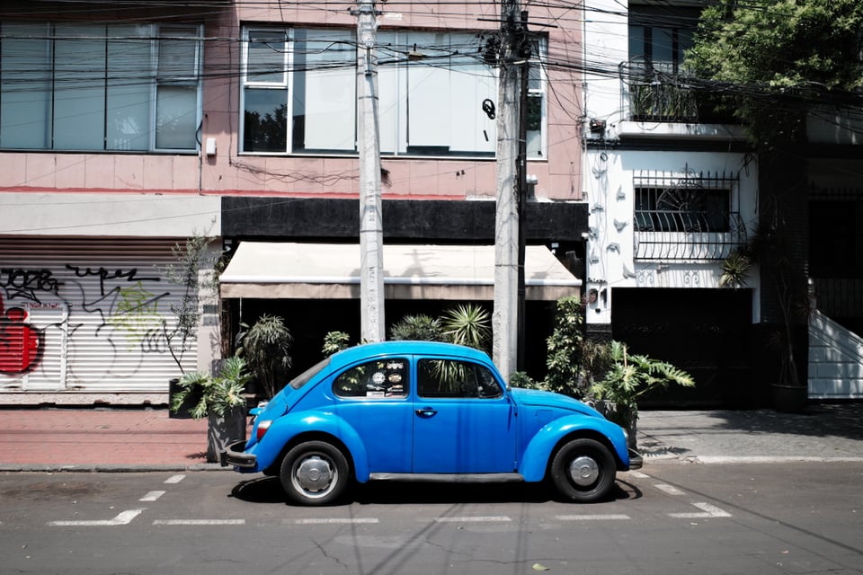 A blue car on the streets of Roma Norte.