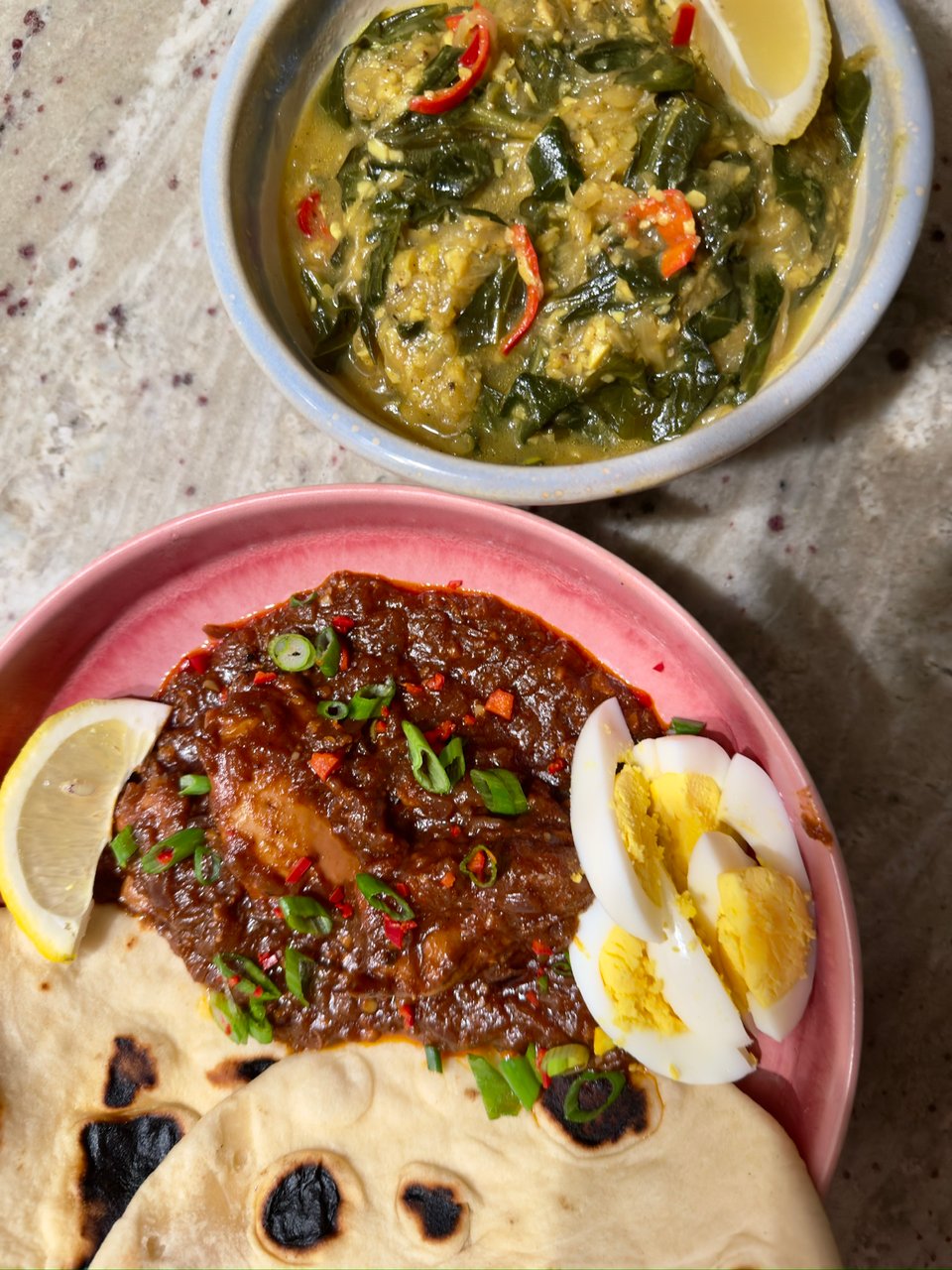 Ethiopian stewed collard greens (top) served alongside doro watt and naan (bottom).
