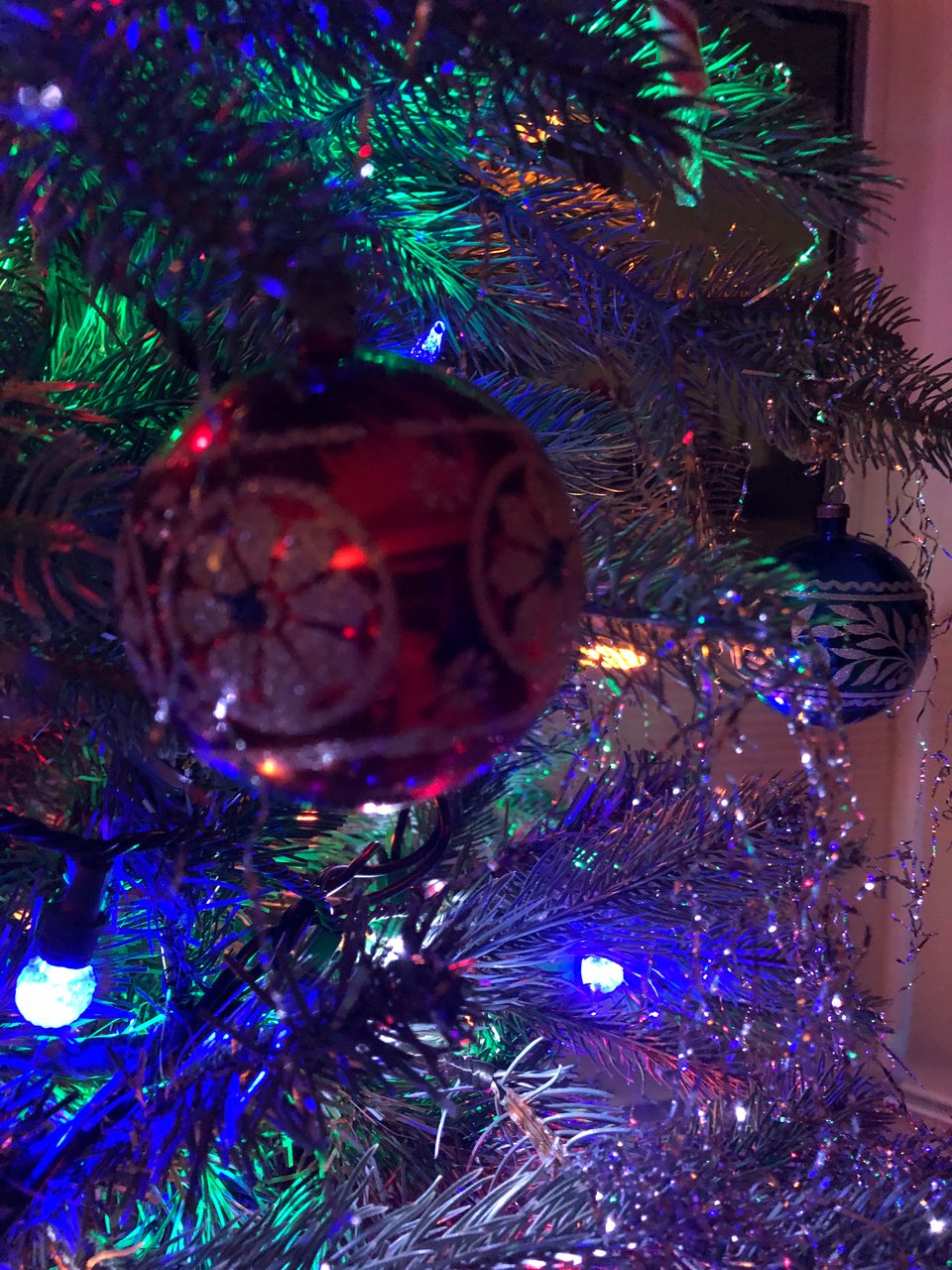 closeup of two Cmas tree ornaments, one red and one blue