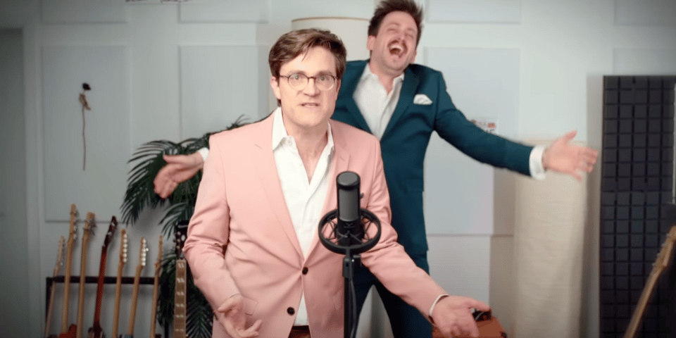 Two men bounce around in pastel suits.