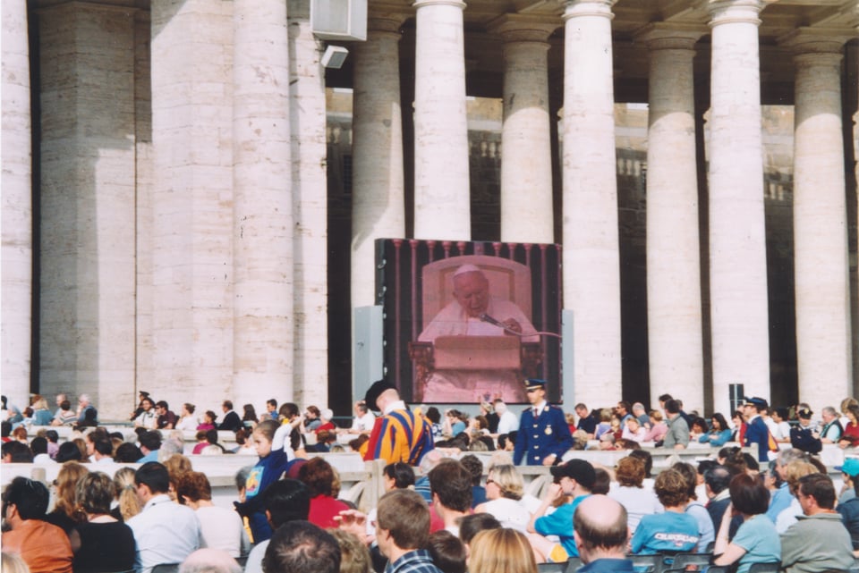 Pope John Paul II on a screen in front of an audience