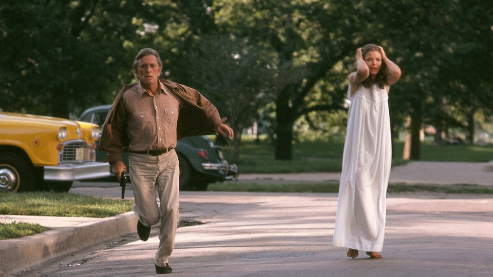 a man running and woman in a white nightgown walking down a street