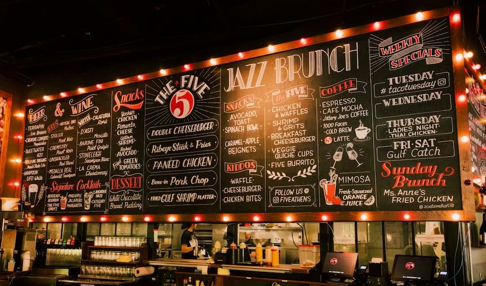 A hand-drawn menu board in white, red, and black