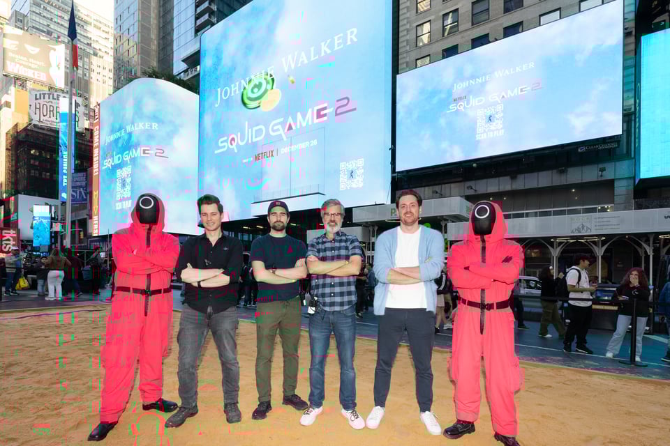 Justin Ayers, Jordan Drake, Charlie Todd, Andrew Soltys and two Pink Guards stand on the sand field