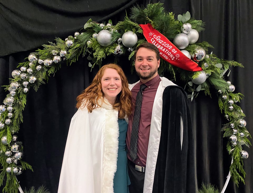 Jake and Liz dressed up posing for a picture at COSI