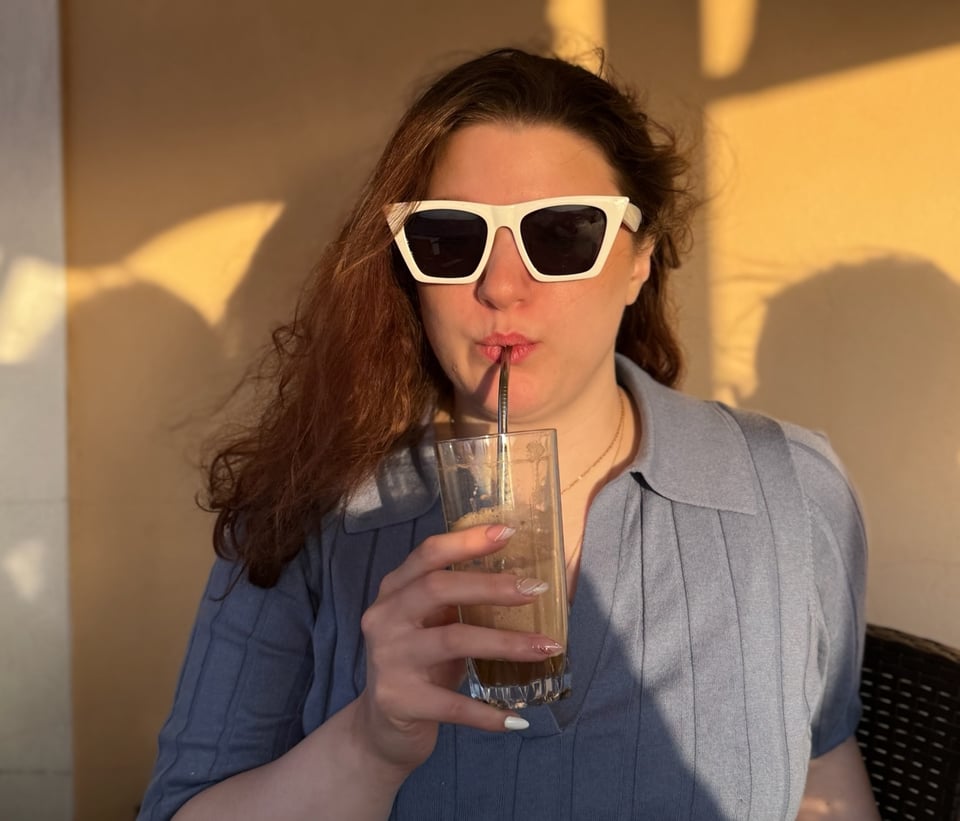 Lily wearing white sunglasses and drinking a frappe