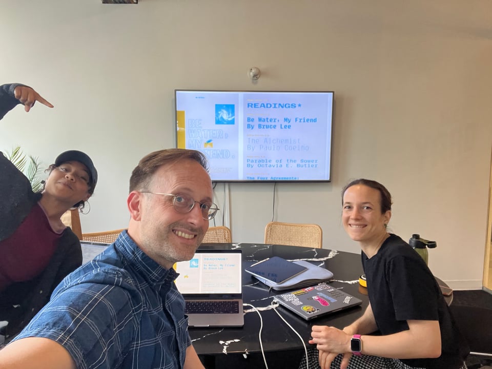 Tyler, Jesse, and Zrinka looking at a proof of a specimen for the typeface Plumbago. Specimen is designed by Work/Play.
