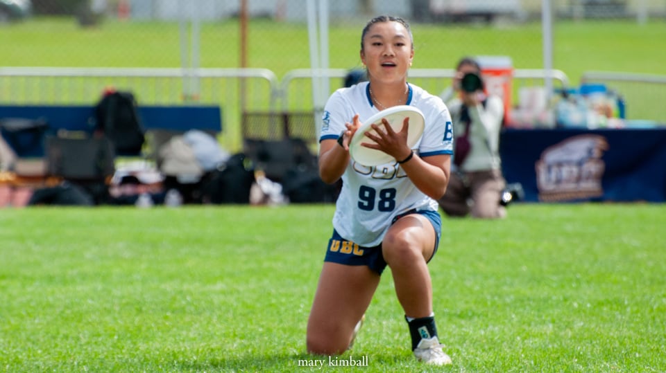 UBC player Lauren Szeto-Fung was perfectly situated in the endzone to catch the disc and win the finals on universe point for her team at the USAU D-I Women’s College Championship. She holds the disc in her hand and looks a little stunned but confident. 