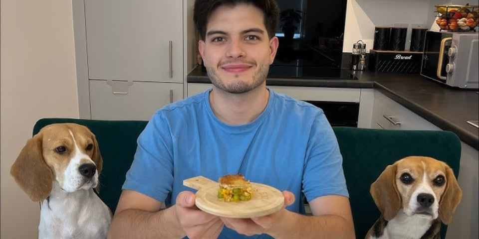 One man smiling before his beagles begin to attack him for his food.