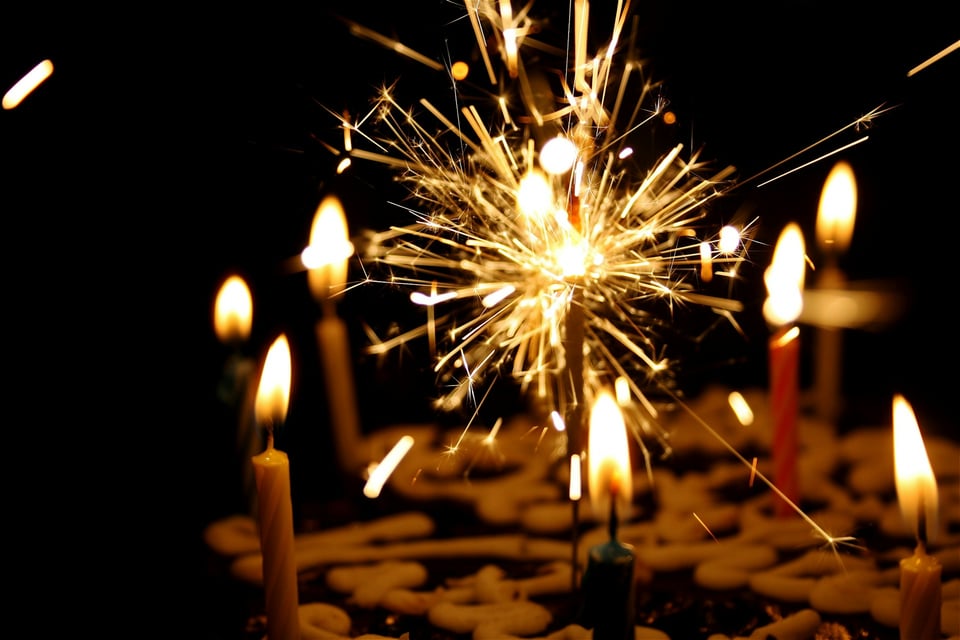 A close-up photo of candles on a cake. Photo by Nikhita Singhal on Unsplash.