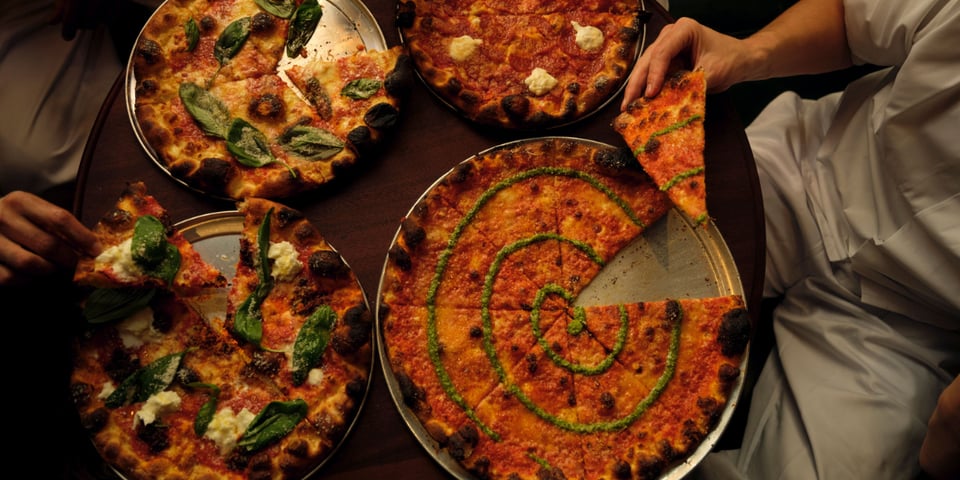 Some lovely looking pizzas, one with a distinctive pesto swirl.