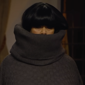 A woman wearing a comically large turtleneck sweater