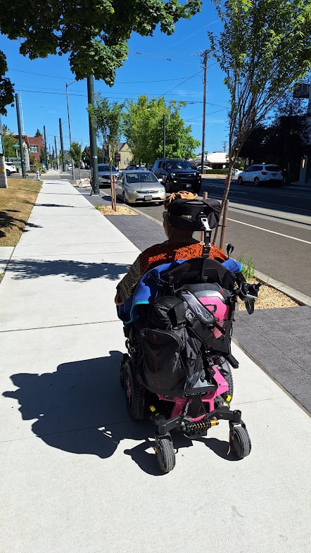 A photo of my mom in her power chair going down MLK