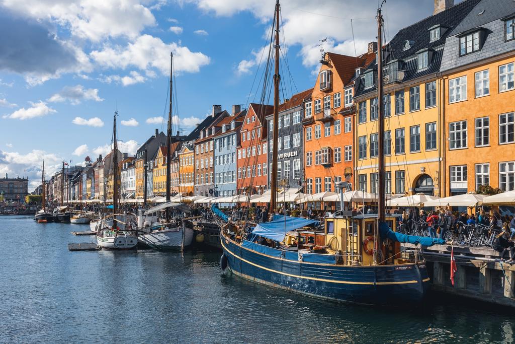 Colorful gabled houses and wooden sailboats along Nyhavn canal in Copenhagen