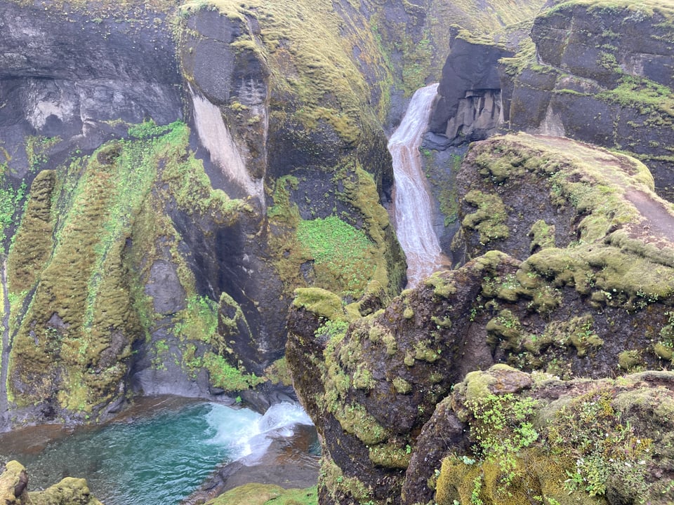 The inside of a river canyon, the walls black stone and covered with green moss. There's a waterfall AND a little river. Absolute fantasy land shit. 