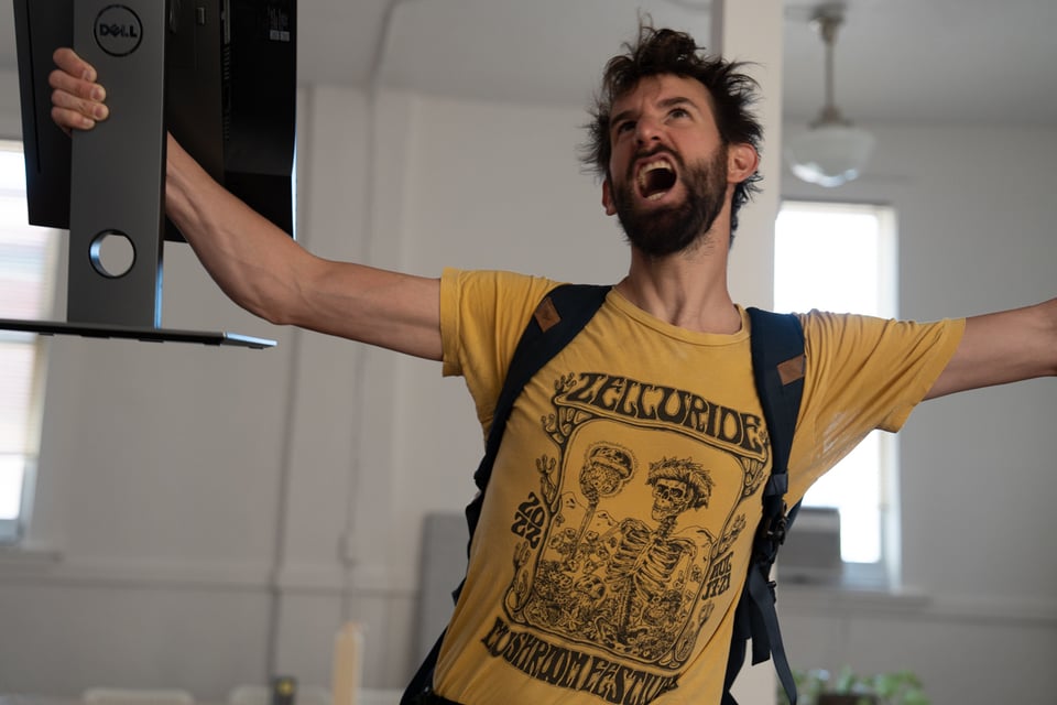 Drew holding a monitor victoriously.