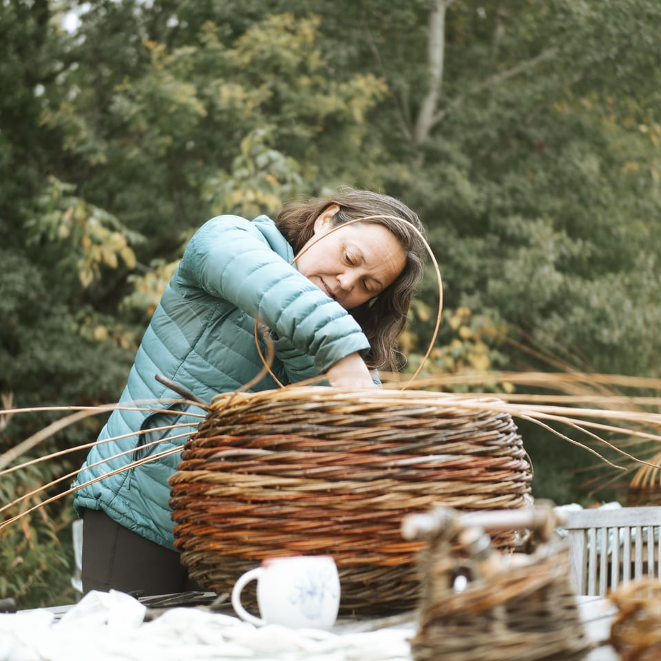 Weavers working on their large twisted willow baskets