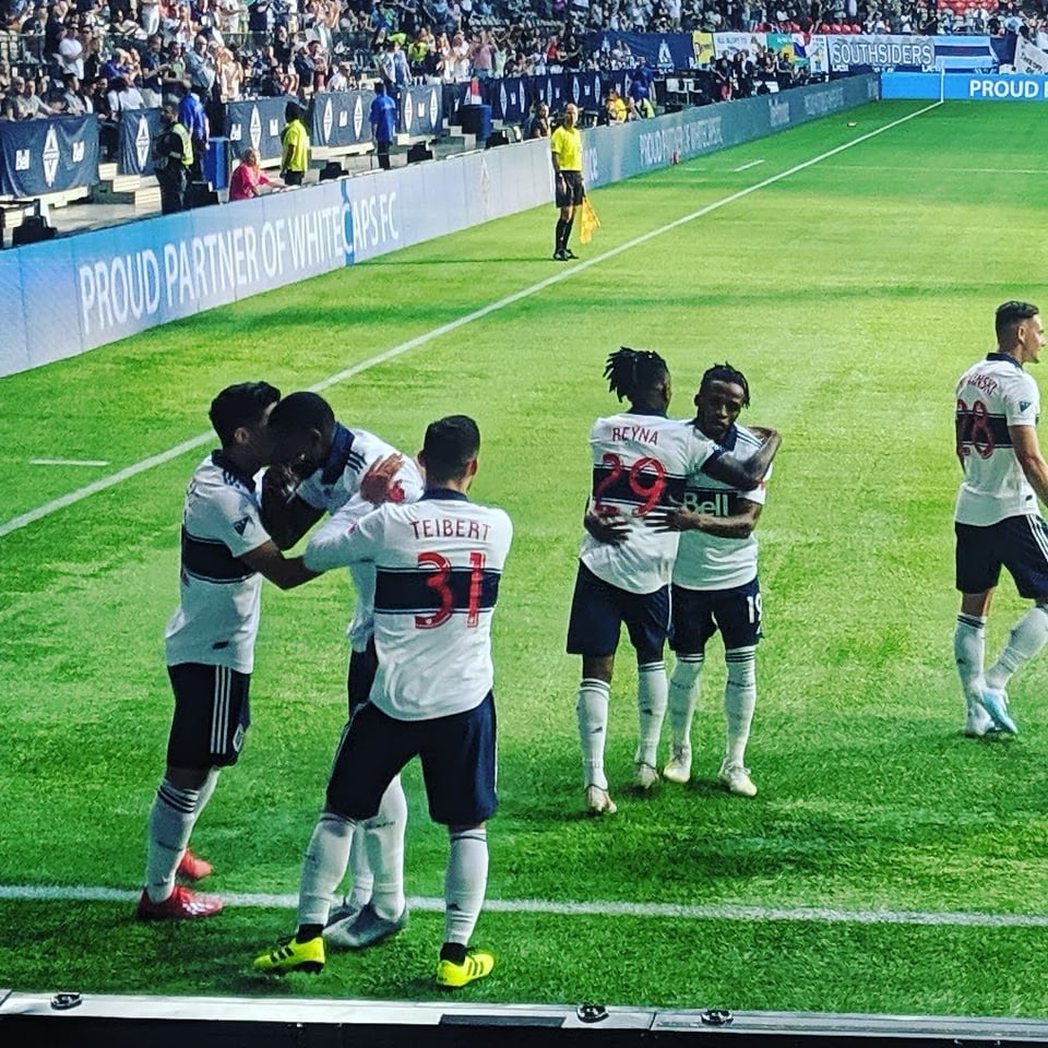 A view of multiple Whitecaps FC players after a Whitecap player scored a goal.