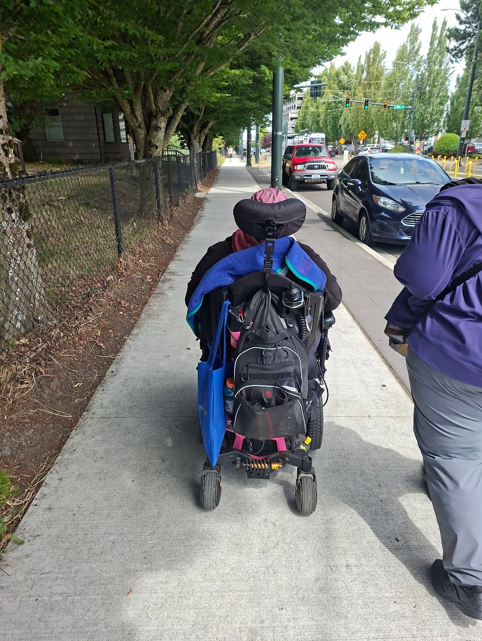Mom and her caregiver, [Redacted], walking along a new sidewalk on MLK next to the light rail